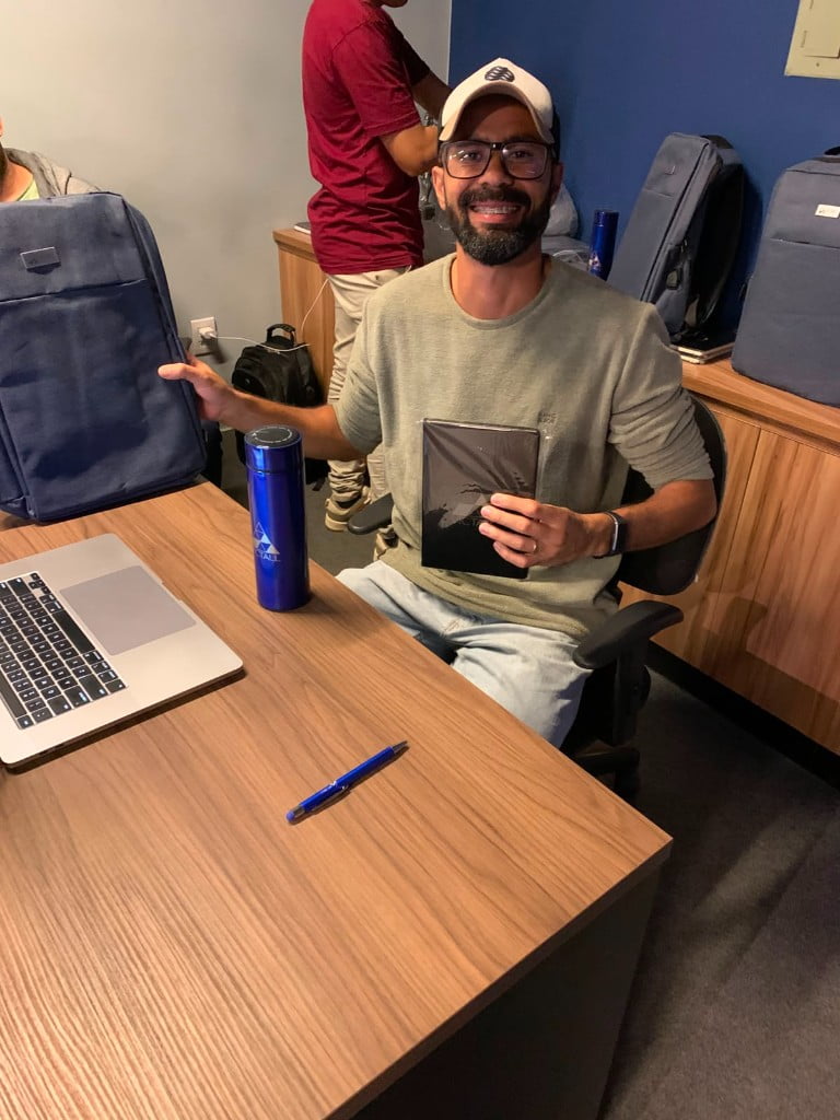 Aluno com mochila e caderno do kit presencial